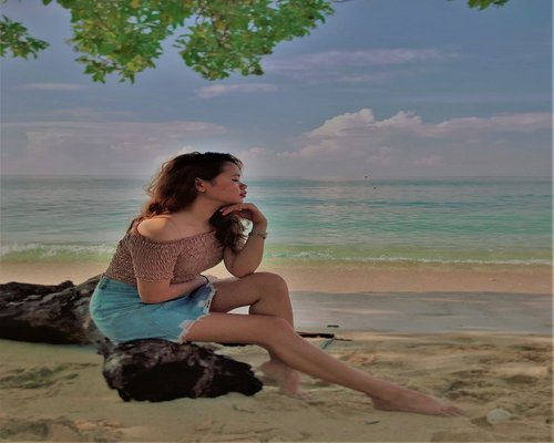 Woman relaxing on the beach looking at the sea